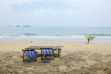 Beach chair on white sand with sea wave and sunny. Relaxing on the beach.
