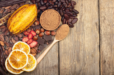 cacao pods, carob pods and dried fruits on wooden background