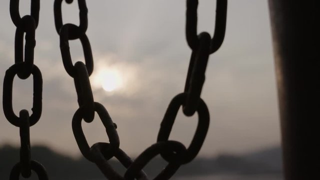 Silhouette slow motion chain with clouds behind