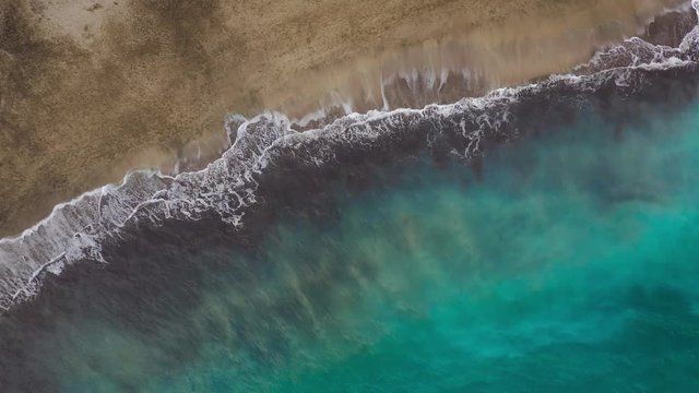 Top view of the desert beach on the Atlantic Ocean. Coast of the island of Tenerife. Aerial drone footage of sea waves reaching shore