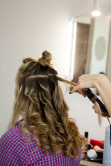 curling hair natural light brown hair in the salon