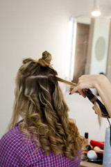 Fototapeta premium curling hair natural light brown hair in the salon
