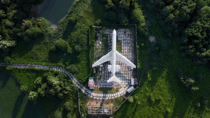 Fototapeta premium old abandoned plane standing in green field. aerial view, drone shot, bird's eye