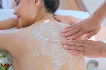 Asia beautiful  woman enjoying a salt scrub massage at the health spa in Thailand