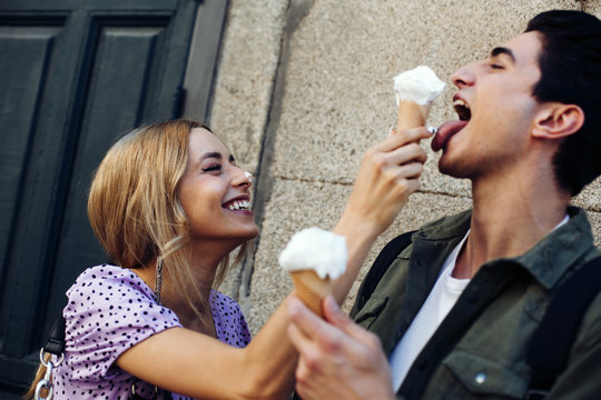 Smiling woman feeding ice cream to her boyfriend