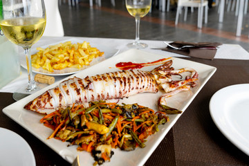 Grilled big squid  (Calamar a la Plancha)  -  typical Spanish tapas. Gourmet dinner in the sea food restaurant in the Getares, Algeciras. Southern Spain is a paradise for sea food lovers.