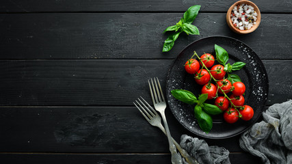 Cherry tomatoes and basil in the plate. Top view. Free space for your text.