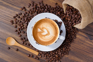 white coffee cup and roasted coffee beans around