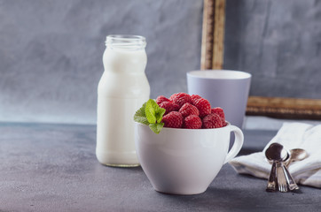 Organic puffed spelt wheat in white bowl with milk and fresh berries for breakfast.