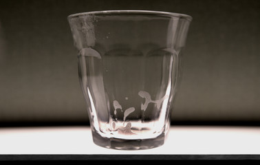 Recently emptied isolated clear glass with residue at the bottom