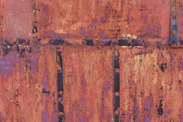 old iron wall consisting of separate pieces of metal. metal patches. Metal sheets from which the area is paint. Iron rusting.