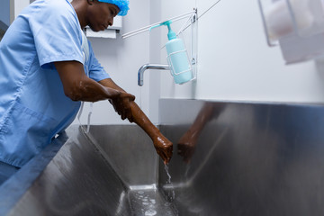 Male surgeon washing hands in sink at hospital - Powered by Adobe