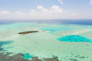 Onok Island Balabac, Philippines. The island of white sand on a large atoll, view from above. Tropical island with palm trees. Seascape with a paradise island.