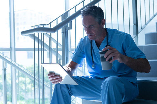 Male doctor using digital tablet on staircase in the hospital - Powered by Adobe