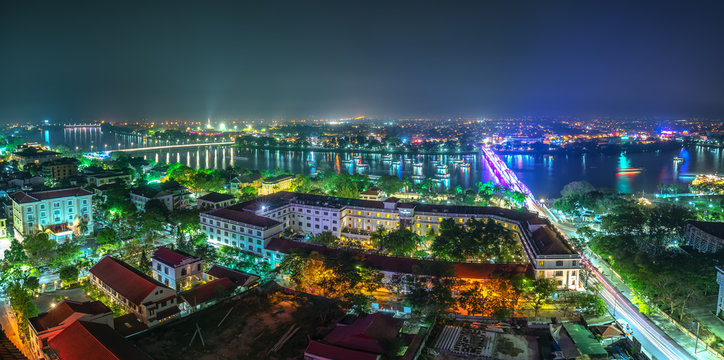 Panoramic city colorful night sparkling view from above in Hue, Vietnam. © huythoai