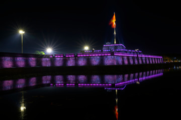 Tower and stone walls shimmering colors around the outside royal Imperial palace at night in Hue, Vietnam.