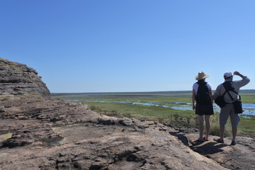 Tourist couple hiking at Ubirr rock art site in Kakadu National Park Northern Territory of Australia