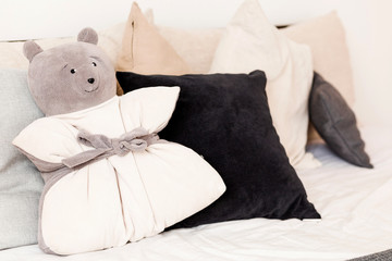 Pillow in the form of a bear lying on the bed