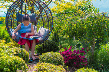 Fototapeta relaksi odpoczynek z książką na ogrodzie wśród kwiatów obraz
