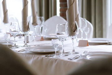 Elegant table setting in the restaurant. Several types of glass, plates and cutlery