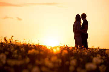 Romantic couple silhouette, sunrise light, white edit space