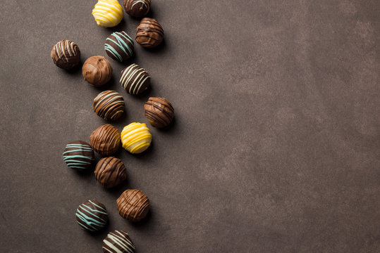 chocolates praline variety on brown background with copyspace