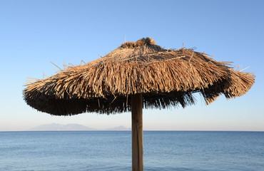 Fototapeta na wymiar Sonnenschirm an einem Strand auf Kos