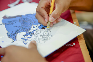Artist Working. Man hands working are using craft knife. Process of hand cutting sticker naga the...