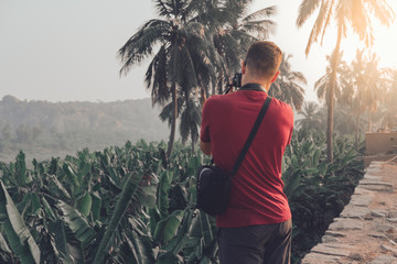 Joven aventurero tomando fotos de campos de arroz en India al atardecer