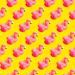 Creative summer beach concept. Seamless pattern from Inflatable pink mini flamingo on yellow...