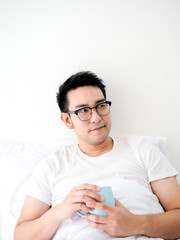 Happy Asian man  drinking coffee on bed, man lifestyle on weekend concept, copy space.