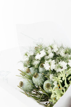 A packed fresh bouquet of flowers, in green and white neutral hues/tones, straight from the flower shop at the market.