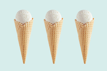 Set of three white creamy ice cream in crisp waffle cones on soft light pastel green background, mock up for design.