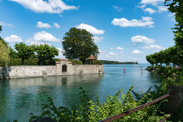 healthy active outdoor couple enjoys paddleboarding on the canals of Lake Constance on a beautiful...