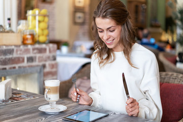 book, news for breakfast. Consumption of news, information. delicious reading e-book. E-book and coffee for breakfast. girl is having breakfast.