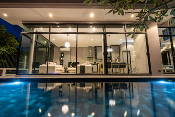 night exterior home with swimming pool in the house