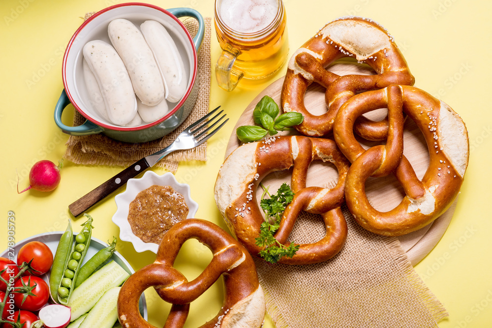 Wall mural Pretzels, white bavarian sausages, mustard and beer, german traditional food, oktoberfest on yellow background