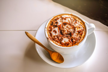 A cap of hot caffee serving on white table