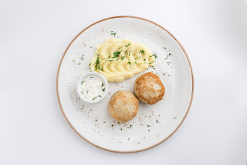 Mashed potatoes and meat balls with white sauce isolated on white background