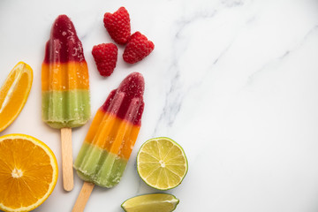 Summer fruit ice lollies made with orange lime and raspberries