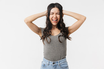 Beautiful displeased screaming young woman posing isolated over white wall background.