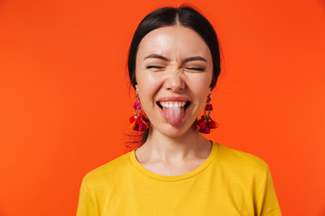 Excited happy young woman posing isolated over orange wall background. - obrazy, fototapety, plakaty