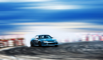 Fototapeta na wymiar Car drifting, Blurred of image diffusion race drift car with lots of smoke from burning tires on speed track