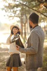 Fototapeta premium Lovely hipster couple enjoying each other. Couple wearing beautiful hats and sweaters. Lifestyle, happy couple of two play on a sunny day in the park. The concept of youth, love and lifestyle. 