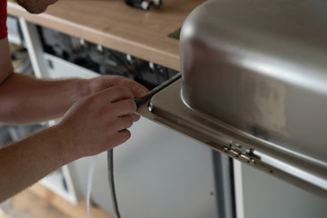 repair and decoration. master sets the sink in the kitchen