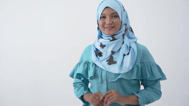 Beautiful veiled woman standing with hands gesture holding something with isolated background