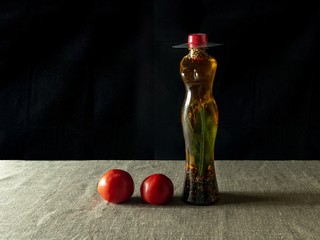Transparent plastic bottle in the shape of a woman with a hat, with various spices and olive oil...