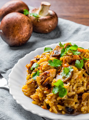 meat with Rice, mushroom and vegetables in white plate on wooden table background
