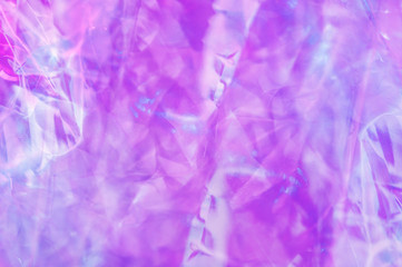 Holographic background in the style of the 80-90s. Real texture of cellophane film in bright acid colors.