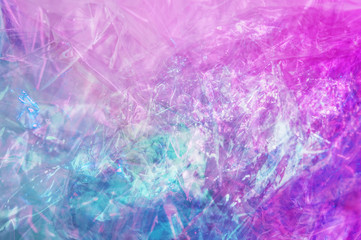 Holographic background in the style of the 80-90s. Real texture of cellophane film in bright acid colors.